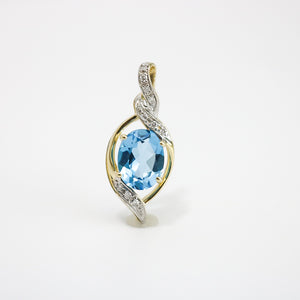 YELLOW GOLD PENDANT WITH 9X7MM OVAL BLUE TOPAZ AND DIAMONDS.