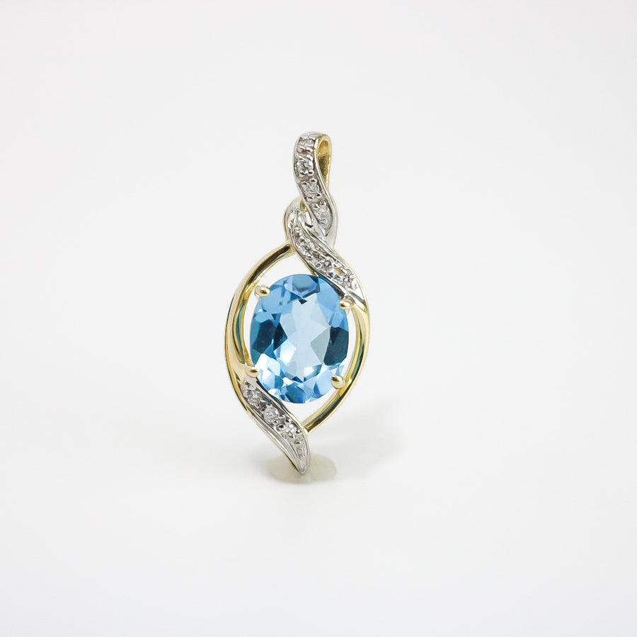 YELLOW GOLD PENDANT WITH 9X7MM OVAL BLUE TOPAZ AND DIAMONDS.